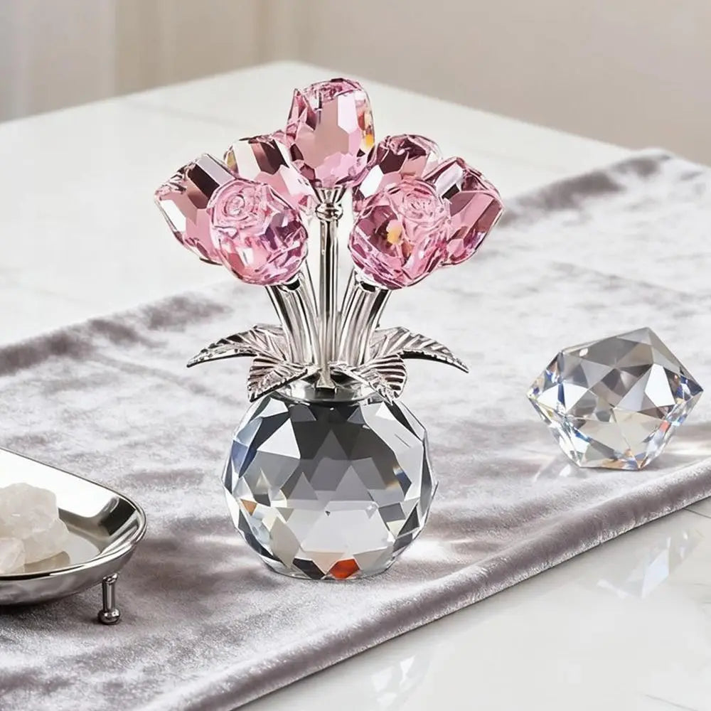 A crystal sculpture featuring a bouquet of pink and clear reflective roses displayed in a glass vase on a gray fabric.