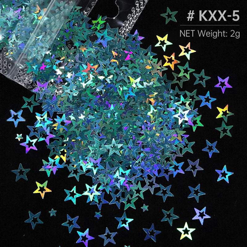 A close-up of shiny holographic star sequins scattered on a black background.