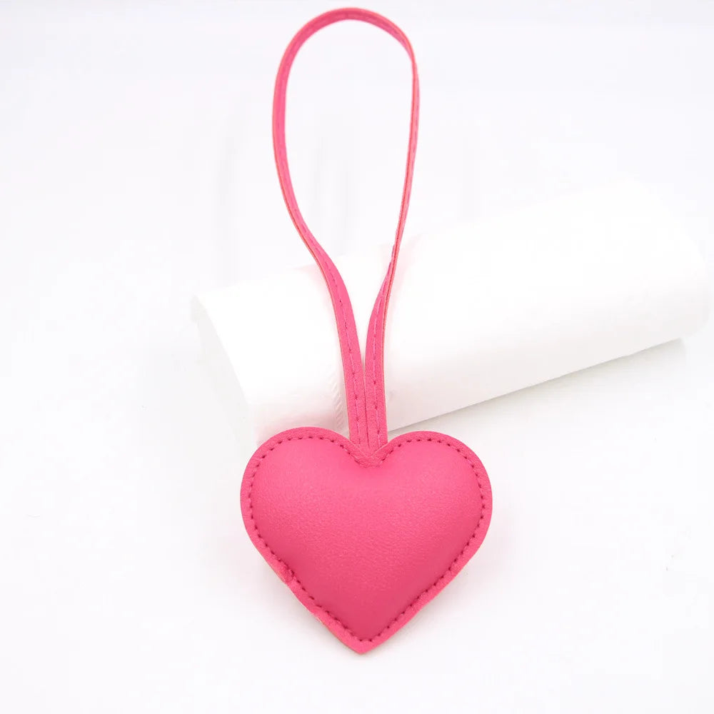 Pink heart-shaped PU leather keychain with a cotton peach charm