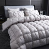 A white goose down duvet with a quilted cotton cover displayed on a bed.
