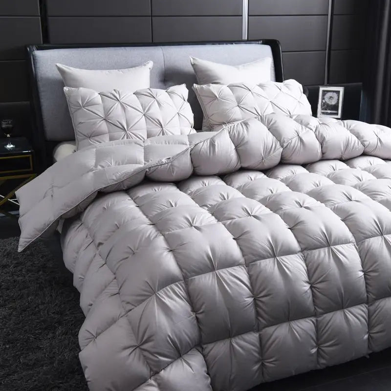 A white goose down duvet with a quilted cotton cover displayed on a bed.