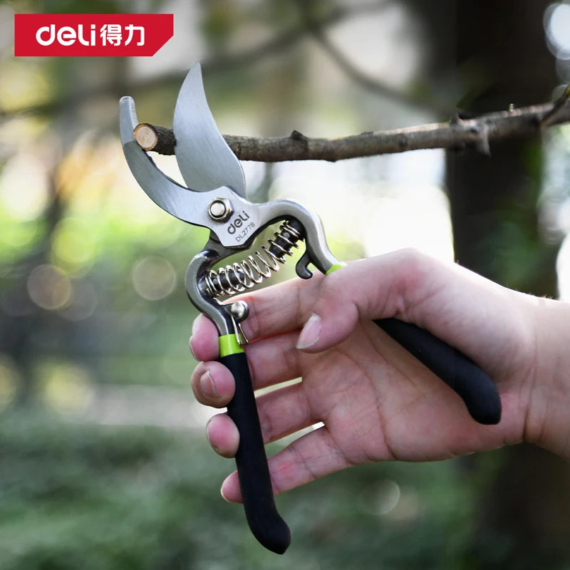 A hand holds a silver pruning shear with a black grip, demonstrating the tool's design.