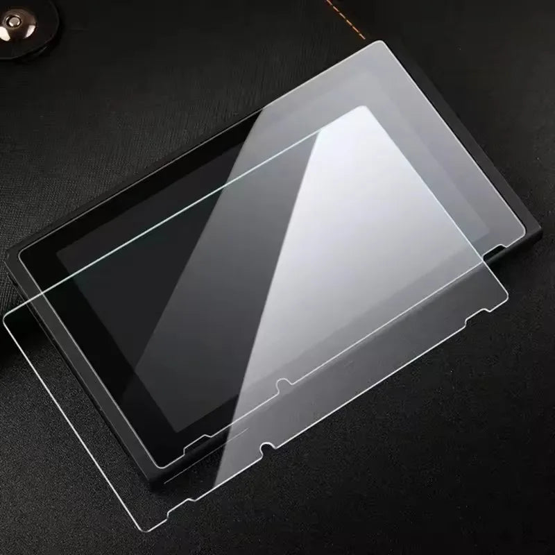 A clear tempered glass screen protector is shown placed on a dark surface.
