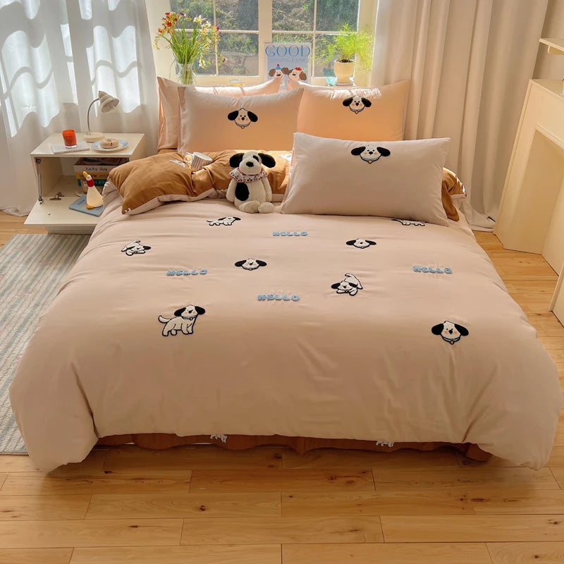 A beige duvet cover set featuring embroidered cartoon dogs on a bed with sheer curtains and a window view.