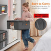 A young girl is carrying a black foldable storage bag with a transparent window, demonstrating its easy portability.