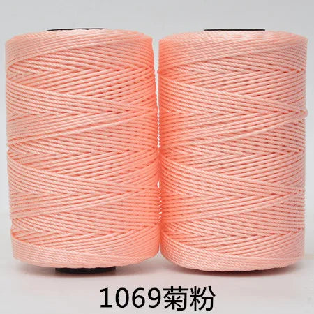 Two spools of pink 3-ply polyester knitting yarn for crochet and hand crafts