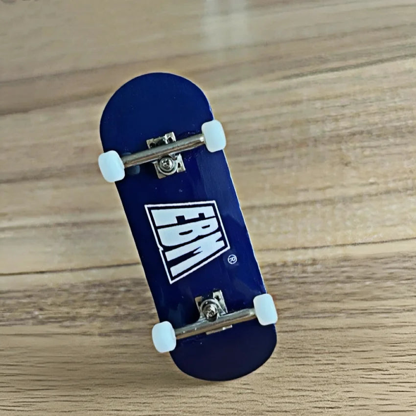 A dark blue skateboard with an EBM logo and realistic trucks resting on a wooden surface.