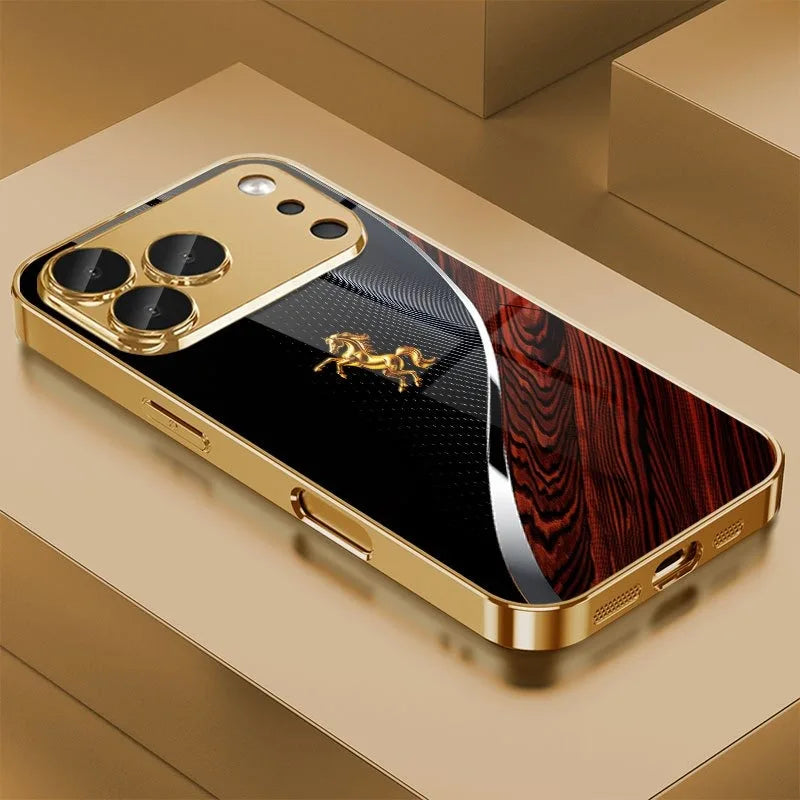 A golden phone case featuring a metallic gold finish and an engraved horse design, resting on a light brown surface.