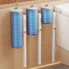 A set of disposable toilet brushes with wall-mounted holders and colorful silicone tops displayed on a beige wall.