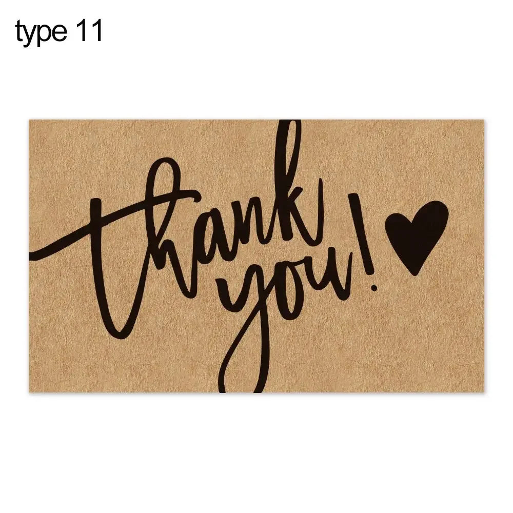 A brown greeting tag with the text thank you written in black script and a black heart symbol.