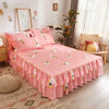 Jupe de lit rose à double couche imprimée avec des accents floraux sur un lit dans une pièce lumineuse.