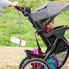 A baby is using an adjustable silicone pacifier chain attached to a bottle on a stroller.