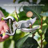 A hand holds a silver bypass pruning shear cutting a branch on a plant, demonstrating the labor-saving curved cutting edge.