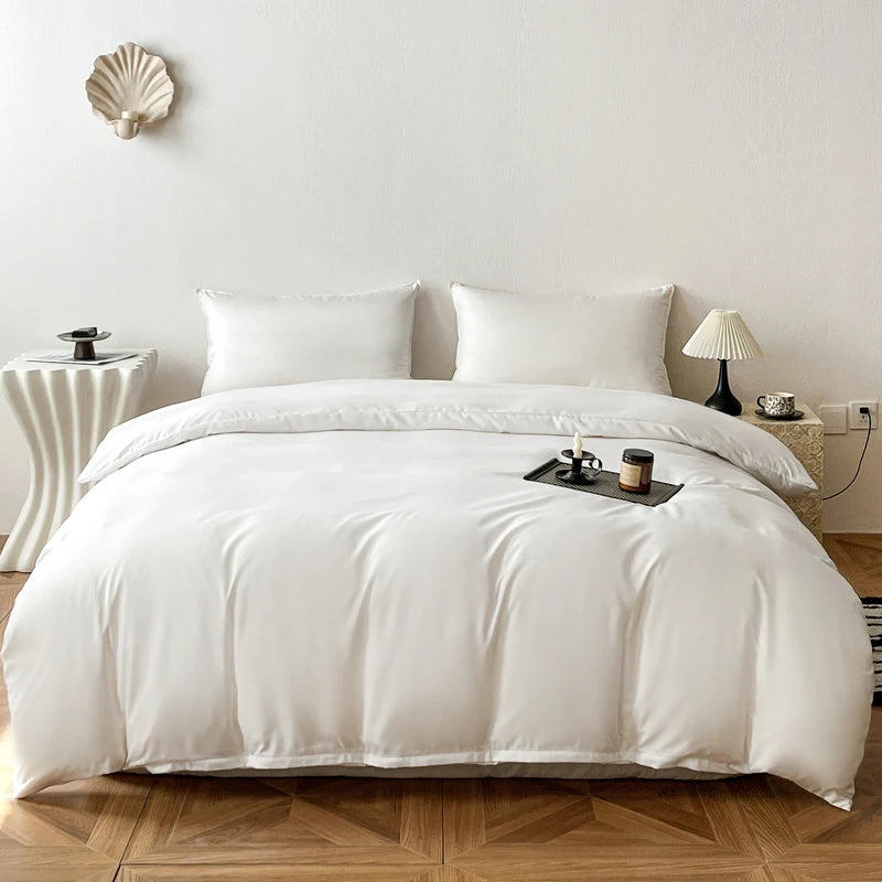 A white duvet cover with a soft, brushed texture is displayed on a bed with white pillows and natural light.