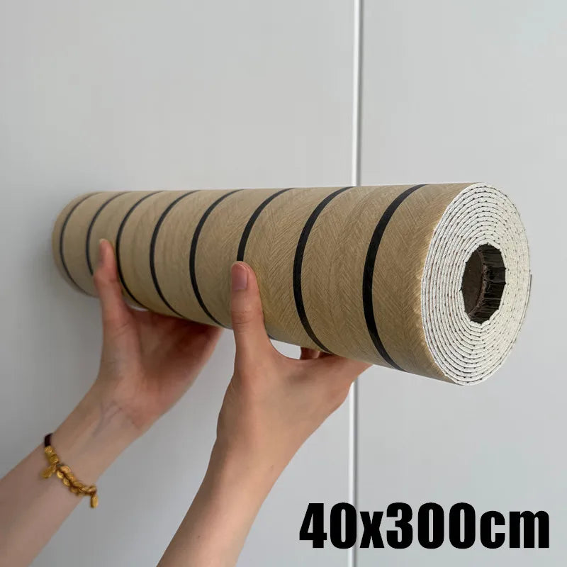 Roll of self-adhesive wood grain wall panels in light brown color being held by a hand.