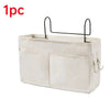 A beige hanging storage organizer with two cotton pockets and black hooks.