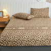 A leopard print fitted bed sheet with an all-around elastic band displayed on a bed.