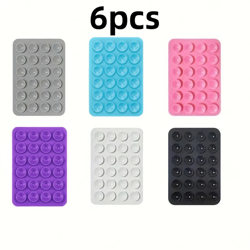 Six reusable silicone suction phone mounts in various colors including gray, blue, pink, purple, white, and black.