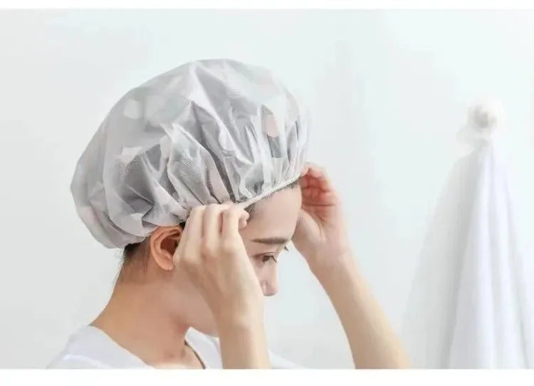 A person is putting on a disposable waterproof shower cap for bathing and hair care.