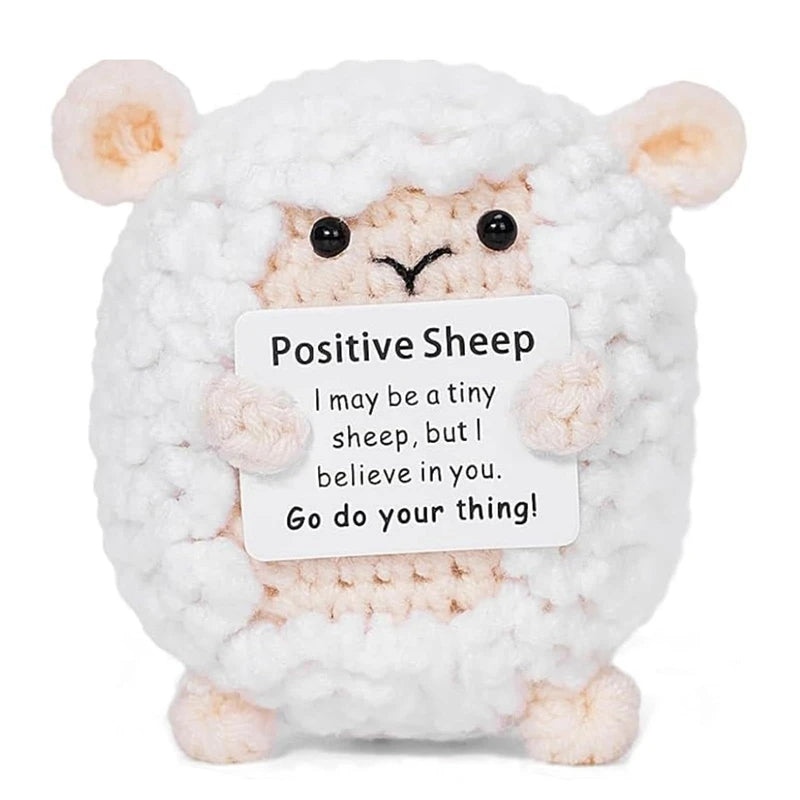 A white and pink fluffy sheep crochet doll with a message card that reads I may be a tiny sheep but I believe in you go do yo
