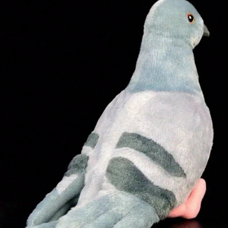 A soft gray plush toy of a pigeon with subtle gray markings against a black background.