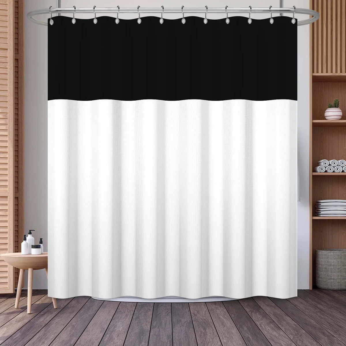 A white shower curtain featuring a black horizontal stripe pattern hanging from a metal rod.