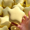 A hand is squeezing soft yellow star-shaped stress relief toys.