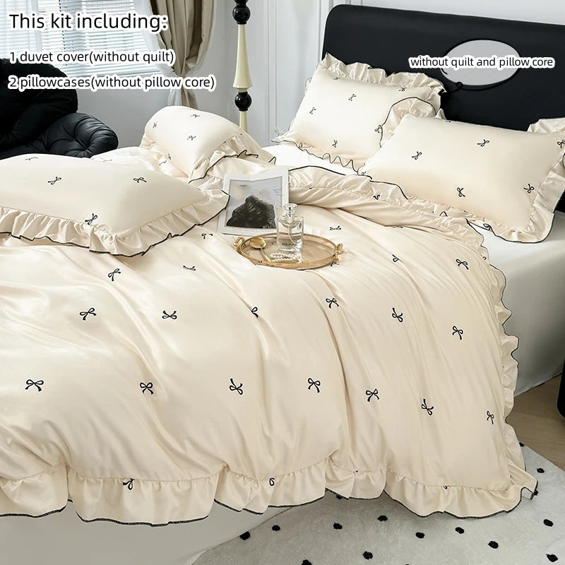 A beige duvet cover set including a duvet cover, two pillowcases, and a pillow core on a black bed.