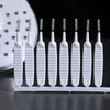 A row of white shower cleaning brushes with spiky nozzles displayed on a white tray.