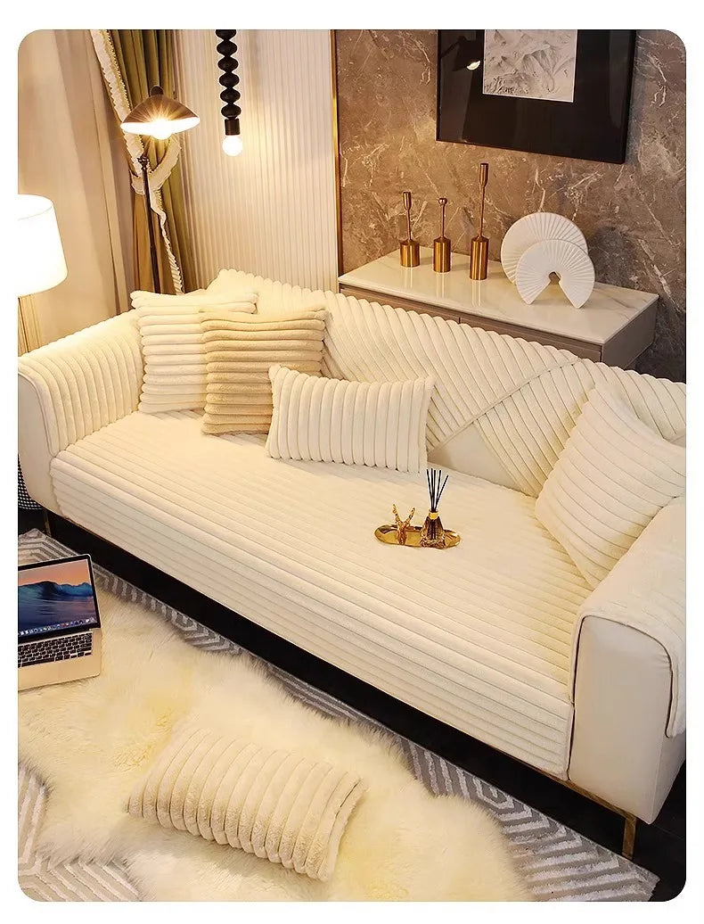 A beige plush anti-slip sofa cushion mat placed on a light-colored sofa with cream pillows and a fluffy rug.