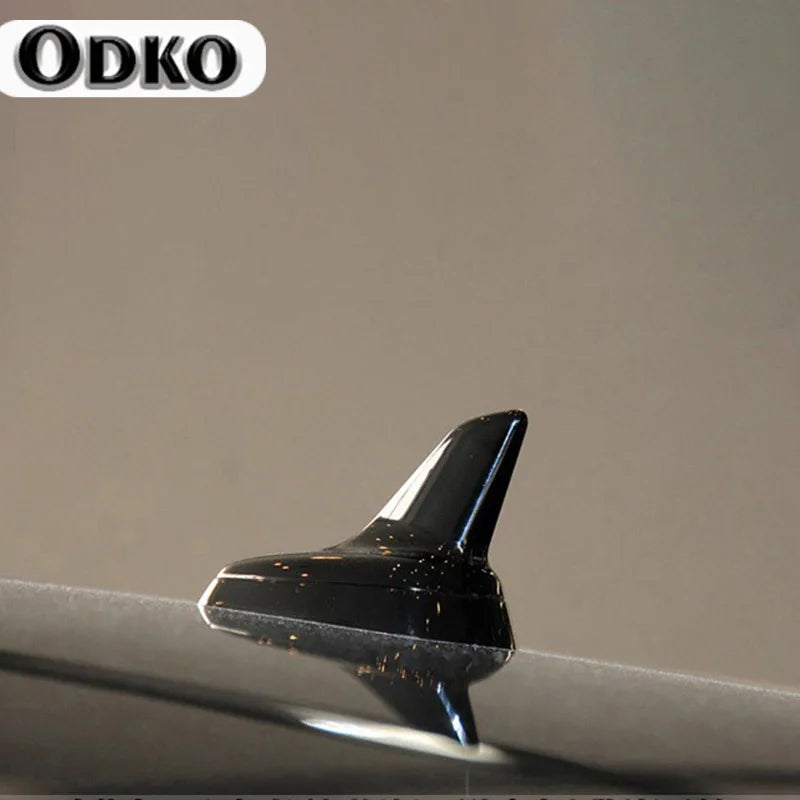 A close-up view of a sleek black shark fin roof antenna for VW and Audi models.
