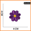 A purple embroidered flower patch with a yellow center, measuring 4 cm in diameter.