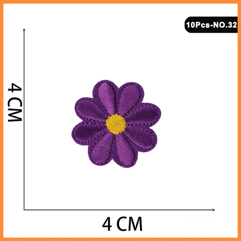 A purple embroidered flower patch with a yellow center, measuring 4 cm in diameter.