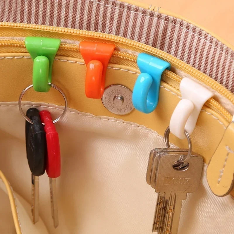 A set of colorful key holder clips and a metal key are displayed on a light yellow bag.
