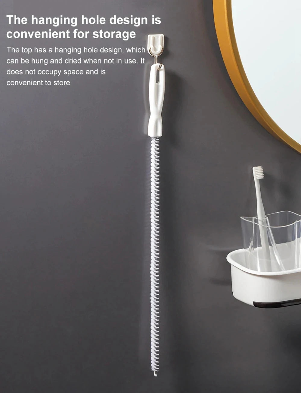 A silver flexible drain cleaning brush hanging on a wall next to a white container.