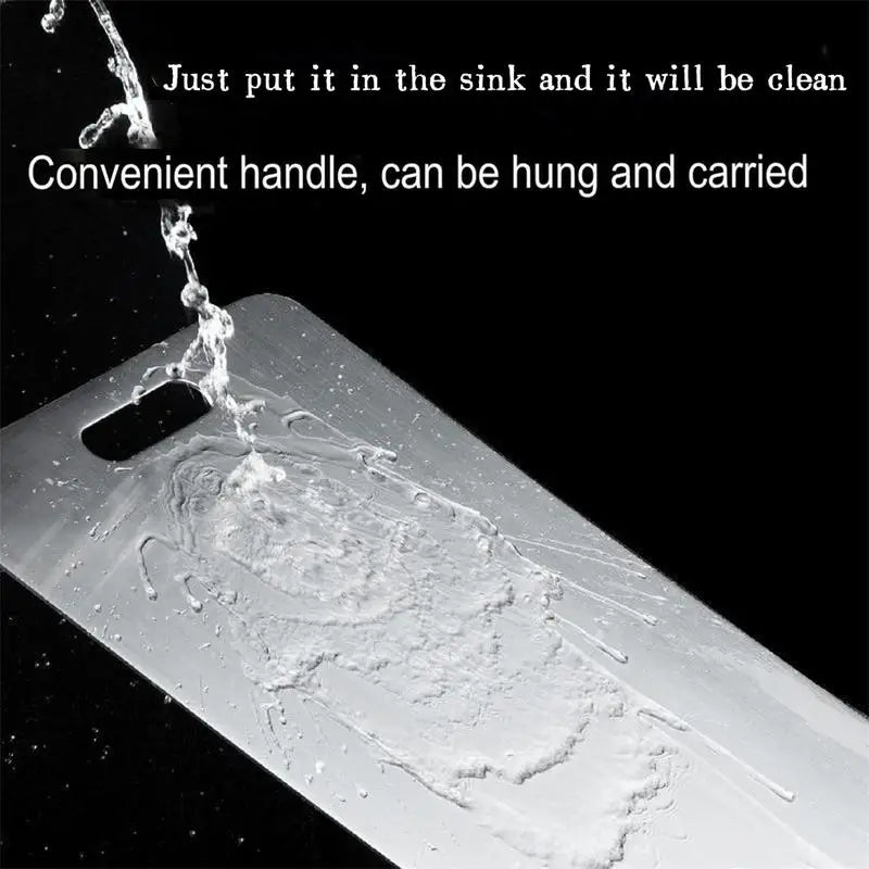 A close-up view of a double-sided stainless steel cutting board being washed in a sink.