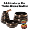 A set of 8.5 to 20cm large Tibetan singing bowls with wooden strikers and decorative cushions.