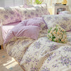 A lavender floral duvet cover set featuring a light background with purple and green floral patterns on a bed.