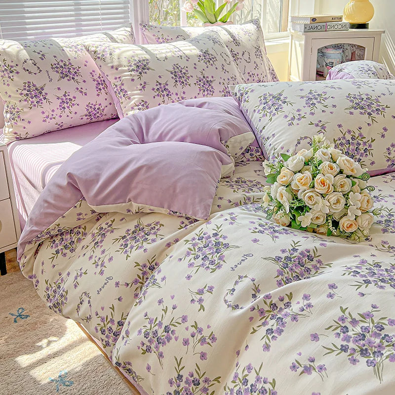 A lavender floral duvet cover set featuring a light background with purple and green floral patterns on a bed.