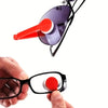A hand holds a black eyeglass frame with a red cleaning brush and microfiber cloth attached.