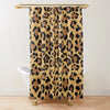 A tan and black leopard print shower curtain hanging from a gold rod.