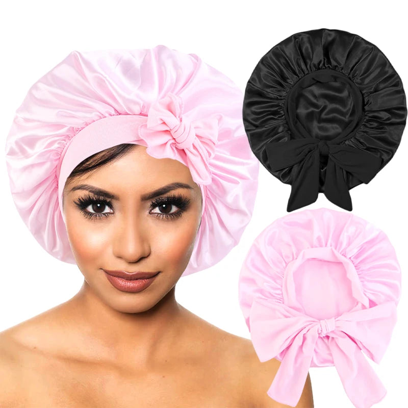 Pink silky satin sleep cap with wide band and a matching black version shown on a model's head