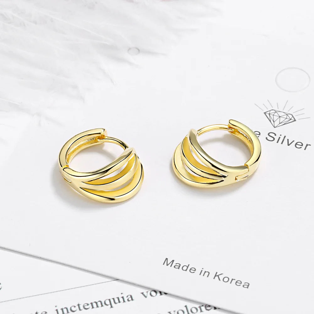 Pair of gold-toned, wavy hoop earrings displayed on a white background.