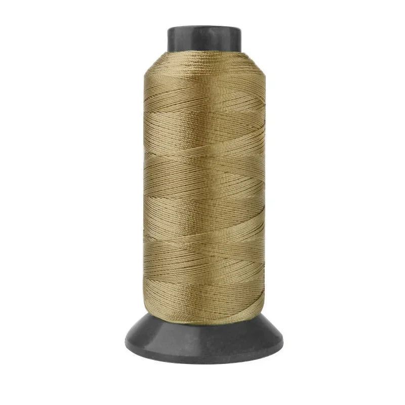 A spool of heavy-duty beige nylon sewing thread for upholstery and denim.