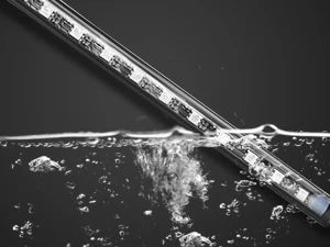 A glass tube of LED light strips is shown being dipped into water, creating a splash effect.