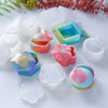 A collection of silicone jewelry boxes and resin molds in various pastel colors, including pink, blue, and green.