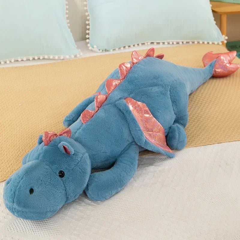 A soft blue dragon plush toy lying on a light-colored surface.
