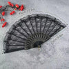 Black vintage lace folding hand fan with a durable handle shown against a gray background.
