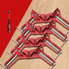 A set of red 90 degree right angle clamps and a single red drill bit are displayed on a wooden surface.