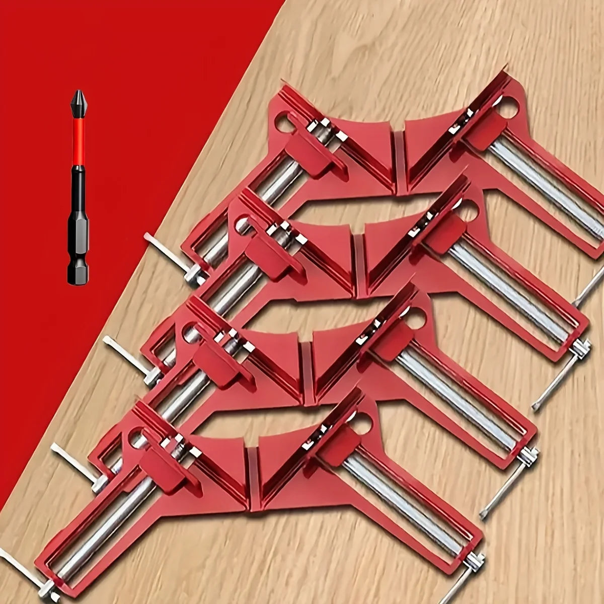 A set of red 90 degree right angle clamps and a single red drill bit are displayed on a wooden surface.